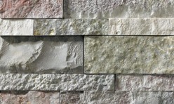 A grey stone veneer with a few pink and green accents perfect for any hardscape idea on the exterior or interior of any home or landscape.