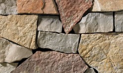 This stack ledgestone features light grey and tan tones complimented with a warm, red accent.