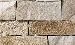 A light grey and tan stone veneer withbrown accents perfect for any hardscape idea on the exterior or interior of any home or landscape.