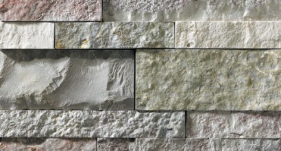 A grey stone veneer with a few pink and green accents perfect for any hardscape idea on the exterior or interior of any home or landscape.