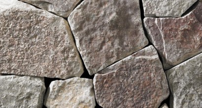 a light grey webwall-style building stone with gold and darker-gray accents.