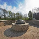 A completed paver patio, valencia fire pit, and sitting walls in Waynesville, OH using products from Belgard and Techo-Bloc.