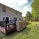 A completed TimberTech deck with a stone planter made from Techo-Bloc Semma wall block.