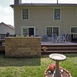 A completed TimberTech deck with a stone planter made from Techo-Bloc Semma wall block.