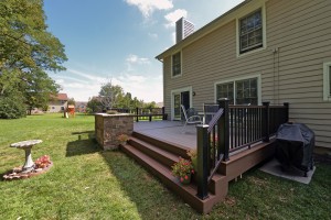 A completed TimberTech deck with a stone planter made from Techo-Bloc Semma wall block.