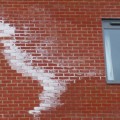 Efflorescence on the side of a brick building.